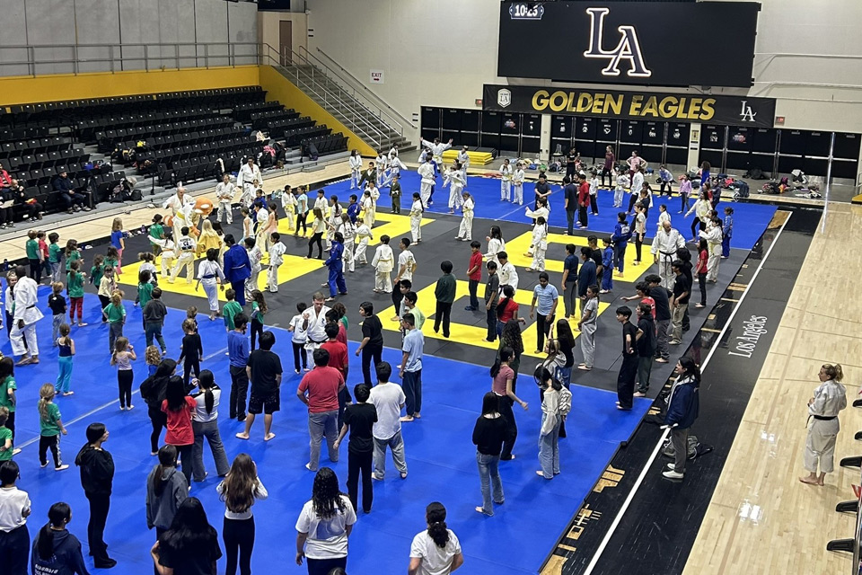 The Cal State LA gym with many young children practicing judo.
